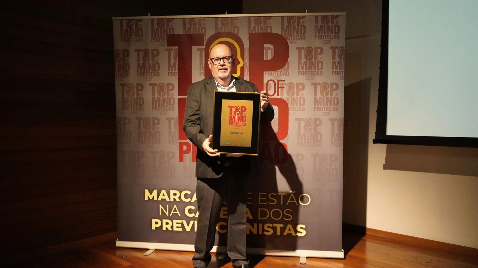 Antonio Carlos Vendrame segurando a placa Top of Mind Proteção 2026